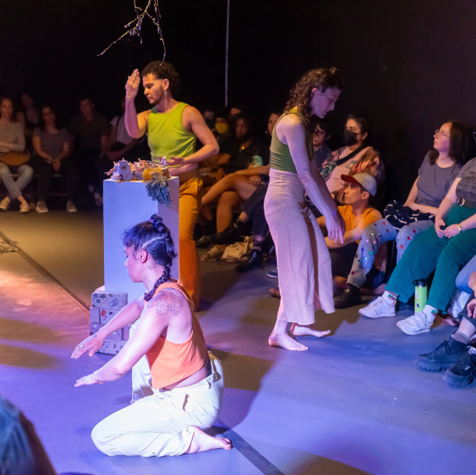 three dancers face left and right surrounded by audiences